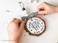 someone is decorating a wood slice with the word mom on it