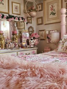 a bedroom with pink furniture and pictures on the wall