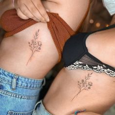 two women with tattoos on their stomachs and one has a flower tattoo on her side