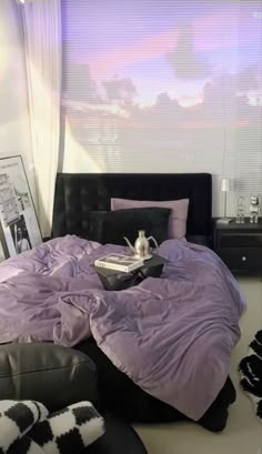 a bed room with a neatly made bed next to a window and pictures on the wall