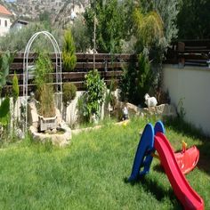 a child's play area in the backyard with a slide and sandbox set