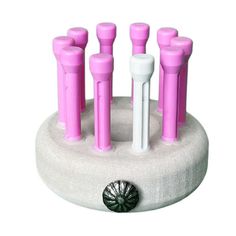 a group of pink and white toothbrush holders sitting on top of a round holder