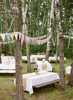 an outdoor party with tables and chairs in the woods