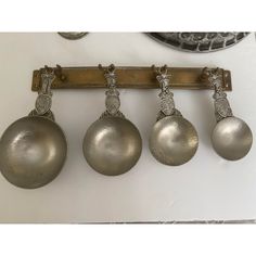 four silver spoons hanging from a brass rack