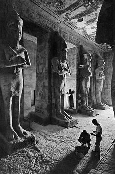 an old black and white photo of some people in front of ancient egyptian statues at the museum