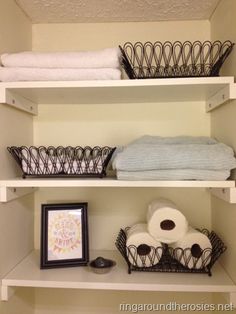 the shelves in the bathroom are organized with baskets, towels, and other household items