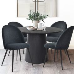 a dining table with four chairs and a plant in the center on top of it