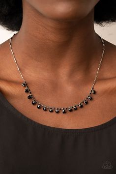 a woman wearing a black and white necklace with beads on it's collarline