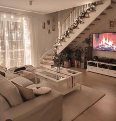 a living room filled with furniture and a flat screen tv sitting on top of a wooden floor