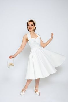 Hello, This magical cream-white halter neck dress made of exclusive elastic jacquard fabric with a diamond pattern will make your big day unforgettable. The circle skirt of the dress swings wide and is ideal for petticoats. Based on the style of the 50s, this dress skilfully accentuates your femininity. Sophisticated folds in the chest area make the dress a timeless companion for your wedding and beyond. We have created a bolero to match this beautiful dress. You can buy this separately here in Halter Neck Dress With Fitted Bodice For Wedding, Halter Neck Wedding Dress With Fitted Bodice, Fitted Halter Neck Dress For Wedding, White Halter Neck Dress With Fitted Bodice, Cream Summer Dress In 1950s Style, Vintage White Petticoat For Party, 1950s Style Cream Summer Dress, Cream 1950s Style Summer Dress, 1950s Style Sleeveless Wedding Dress