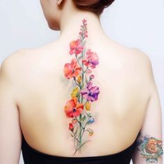 the back of a woman's neck with colorful flowers on her upper and lower part