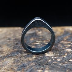 a black ring sitting on top of a rock