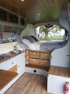 the interior of a camper with wood flooring and storage drawers on each side