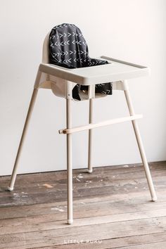 a white high chair with a black bag on it