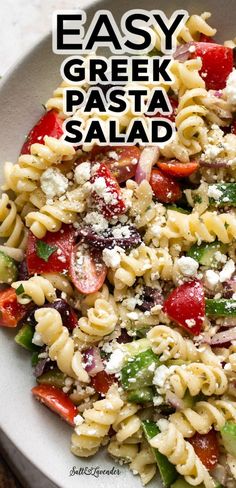 pasta salad in a white bowl with feta cheese and tomatoes