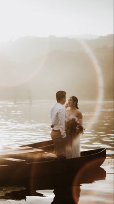 a bride and groom are standing in a row boat