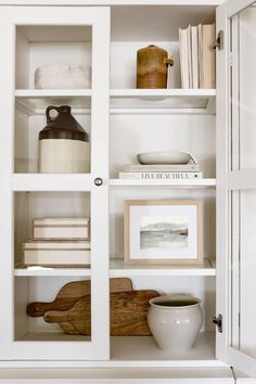 a white bookcase filled with lots of books and knick - knacks