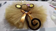 a pair of mouse ears is attached to a tutule with gold sequins