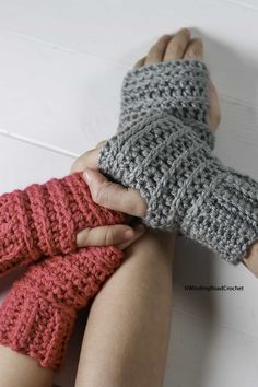 two hands are holding each other while wearing knitted mittens and fingerless gloves