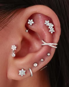 an ear with three different types of piercings