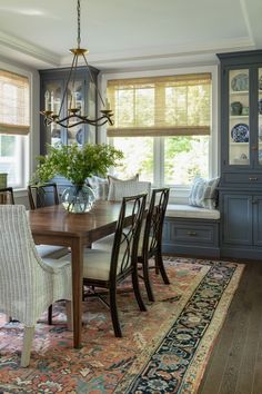 a dinning room table with chairs and a bench in front of the dining room window