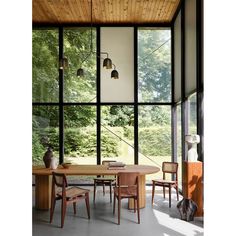 a dining room with large windows and wooden furniture