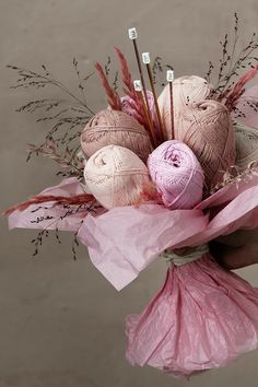 a pink bouquet with yarn and needles in it