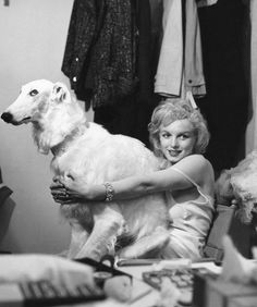 a woman sitting in a chair holding a dog