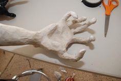 a white dog statue sitting on top of a counter next to scissors