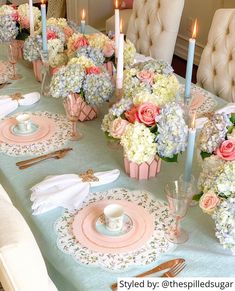 the table is set with pink and white flowers