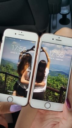 two women holding up their cell phones in the back seat of a car, one with her arm around the other's shoulder