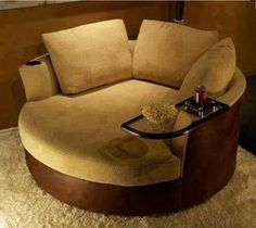 a living room with a round couch and coffee table on the carpeted flooring