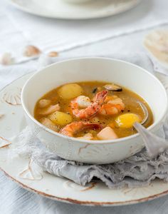 a bowl of soup with shrimp and potatoes