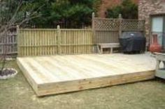 a large wooden deck in the middle of a yard