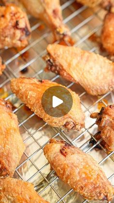 chicken wings cooling on a wire rack with a video play button in the middle of them