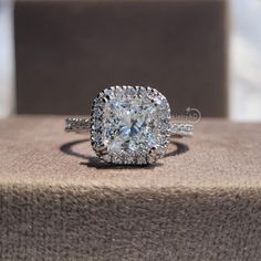 a cushion cut diamond ring on top of a box