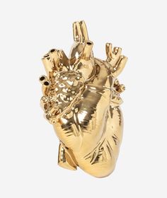 a gold heart shaped brooch sitting on top of a white surface