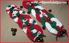 two crocheted christmas stockings with bells and candy canes on the bottom one is red, white and green