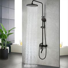 an open shower head with water flowing from it and a potted plant in the corner