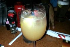 a close up of a drink in a glass on a table with other drinks and condiments