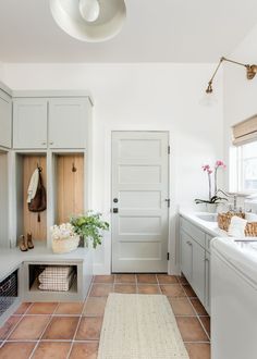 a clean and organized laundry room with lots of storage