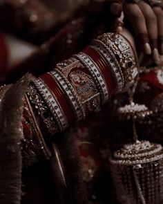 a close up of a woman's arm with bracelets and rings on it