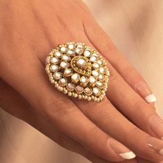 a woman's hand wearing a gold ring with pearls on the middle and sides