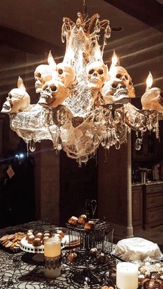 a chandelier hanging over a table with pastries on it and candles in front of it