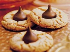 three cookies with chocolate icing are on a table