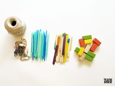 several craft supplies are laid out on a white surface next to a spool of yarn