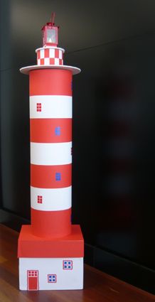 a red and white lighthouse on top of a wooden table