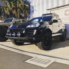 two suvs parked next to each other in front of a building with graffiti on it