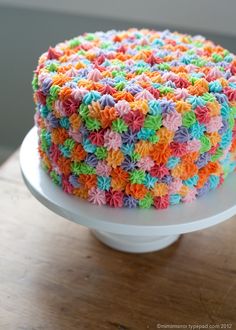 the cake is decorated with multicolored icing