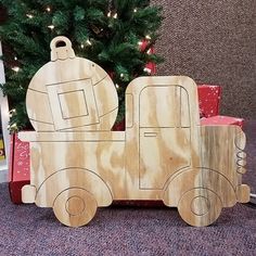 a wooden toy truck next to a christmas tree